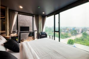 a bedroom with a large bed and a large window at The View Chiang Dao Hotel in Chiang Dao