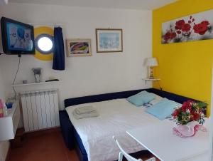 a small bedroom with a bed and a television at Felciaio in Capoliveri