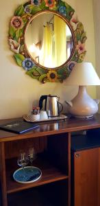 einen Tisch mit einem Spiegel, eine Teekanne und eine Lampe in der Unterkunft Poggio al Sole in Fiesole