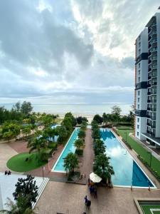 an overhead view of a large swimming pool next to a building at D'Sunset Guesthouse TIMURBAY SEAFRONT -KUANTAN in Kuantan