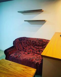 un soggiorno con divano rosso e scaffali di # Crespo Suites # a Rosario