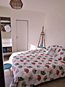 1 Schlafzimmer mit einem Bett mit Blumenbettdecke und einer Leiter in der Unterkunft Beach House avec jardin 200m de la plage in La Couarde-sur-Mer