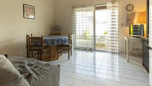 - un salon avec un lit, une table et une télévision dans l'établissement Les Ondines 2- 25- Maison mezzanine- 6 pers, au Cap d'Agde