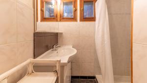 un bagno bianco con lavandino e doccia di Les Cochettes -166 - Chalet spacieux 8 pers a Doucy Altre 7 foto