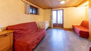 a living room with a couch and a bed and a window at Les Cochettes -166 - Chalet spacieux 8 pers in Doucy