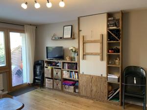 sala de estar con estante de libros y TV en Verbier Medran apartment, en Verbier