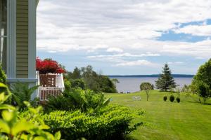 a house with a yard with a view of the water at Captain Nickels Inn in Searsport