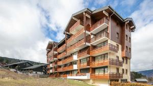 a building with balconies on the side of a hill at Les Eterlous- 19- Appart pied des pistes- 6 pers in Morillon