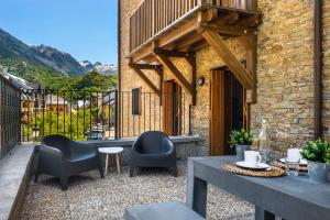 eine Terrasse mit Stühlen und einem Tisch mit Aussicht in der Unterkunft Casa Lobo Panticosa in Panticosa