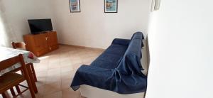 a room with a blue chair and a tv at Appartamenti Giglio Castello in Isola del Giglio