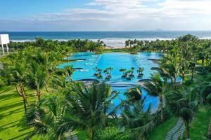 an aerial view of a resort with palm trees and the ocean at JOY Oceanfront Serviced Apartment - Cam Ranh in Miếu Ông