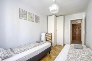 ワルシャワにあるLabo Apartment Panskaのベッドルーム1室(ベッド2台、シャンデリア付)