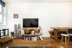 a living room with a flat screen tv and a table at 1BR Retreat near Twickenham Stadium in Twickenham