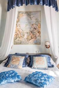 - un lit avec deux oreillers et un tableau mural dans l'établissement Borgo Sanguineto, à Tuoro sul Trasimeno
