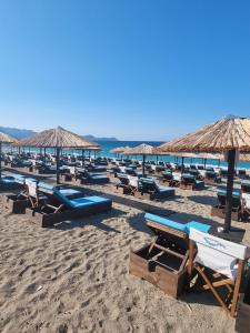 a bunch of lounge chairs and umbrellas on a beach at Aegean Villa in Mourteri