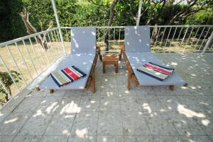 Villa Comfort في قشتيلا: كرسيين وطاولة على الفناء