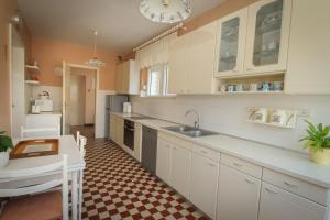 uma cozinha com armários brancos e um piso xadrez em Villa Comfort em Kaštela