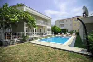 a backyard with a swimming pool in front of a building at Villa Comfort in Kaštela