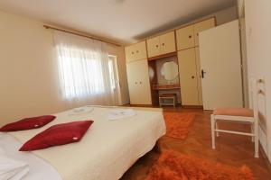 um quarto com uma cama com almofadas vermelhas em Villa Comfort em Kaštela