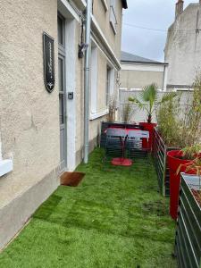 een kleine tuin met een tafel en groen gras bij Le gite des 3 mousquetaires in Amboise