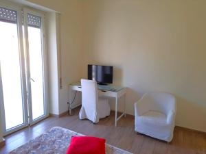 Zimmer mit einem Schreibtisch, einem Computer und einem TV. in der Unterkunft Cozy Rooms Rome in Rom