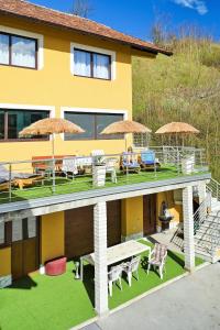 a house with a deck with chairs and umbrellas at Lola's House in Jajce