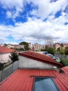 um telhado vermelho numa casa com estacionamento em Studio cosy proche du lac d'Enghien em Soisy-sous-Montmorency