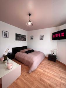 1 dormitorio con 1 cama y un cartel en la pared en Studio cosy proche du lac d'Enghien en Soisy-sous-Montmorency