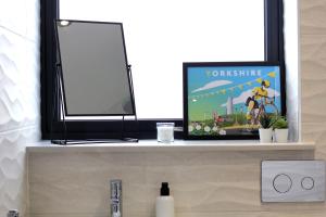 ein Fernseher, der auf einem Regal über einem Waschbecken steht in der Unterkunft West Bar Penthouse FREE Parking in Sheffield