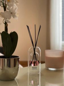 a glass vase with sticks in it sitting on a table at Studio cosy proche du lac d'Enghien in Soisy-sous-Montmorency