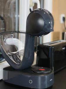 a black mixer sitting on top of a microwave at Studio cosy proche du lac d'Enghien in Soisy-sous-Montmorency