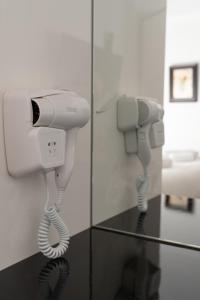 Habitación con secador de pelo y teléfono en Dema Luxury Suites - Lekka E3, en Atenas