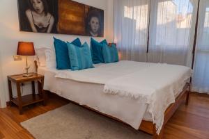1 dormitorio con 1 cama blanca grande con almohadas azules en Trilocale Como Centro, Esclusivo 100 MQ con 3 Balconi, en Como