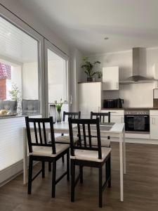 a kitchen with a table and four chairs in a room at Ferienwohnung "Delftbrise" Emden in Emden
