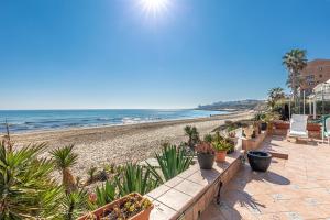 a beach with a row of potted plants at Beachfront Bliss: Apartamento a pie de playa in Alicante