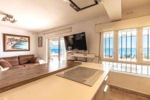 a living room with a couch and a flat screen tv at Beachfront Bliss: Apartamento a pie de playa in Alicante