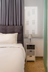 Un dormitorio con una cama y una mesa con una lámpara. en Dema Luxury Suites - Lekka E3, en Atenas