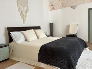 - une chambre avec un grand lit et une couverture noire dans l'établissement Il Villino di GRAZIO, à Monopoli