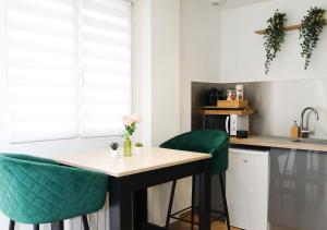 a kitchen with green bar stools and a counter at L’Esmeralda Spa ancien garage devenu suite luxueuse in Évreux