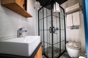 y baño con lavabo y ducha acristalada. en Sofa Hotels Kaleiçi, en Antalya