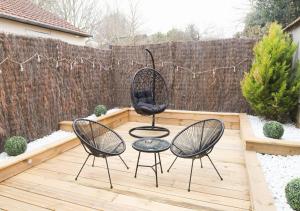 埃夫勒的住宿－L’Esmeralda Spa ancien garage devenu suite luxueuse，庭院设有两把椅子和一张桌子,庭院内有围栏