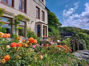 a garden in front of a house with flowers at Bryn Melyn Apartments in Barmouth