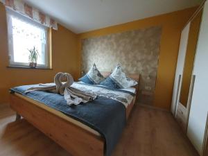 Schlafzimmer mit einem Bett mit blauer Bettwäsche und einem Fenster in der Unterkunft Ferienwohnung-Thale-Ritter in Thale
