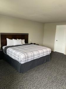 Royal Inn Eugene- Airport في يوجين: غرفة نوم بسرير كبير في غرفة