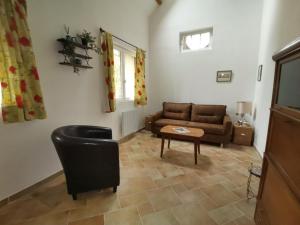 een woonkamer met een bank en een tafel bij La Casita de BEMI in Bois-Jérôme-Saint-Ouen