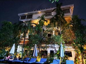 Nary Villa في سيام ريب: فندق فيه كراسي ومظلات امام مبنى