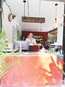 un hombre parado detrás de un mostrador con un portátil en Nary Villa, en Siem Reap