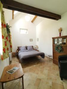 1 dormitorio con 1 cama y 1 mesa en una habitación en La Casita de BEMI en Bois-Jérôme-Saint-Ouen