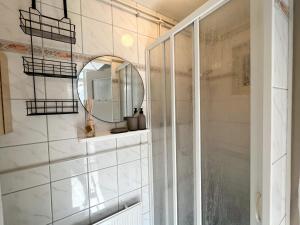 uma casa de banho com um chuveiro e um espelho. em Vakantiewoning aan de Kust 21 em Egmond aan Zee
