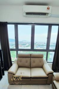 a living room with a couch in front of a large window at J&A Seaview Suites in Perai